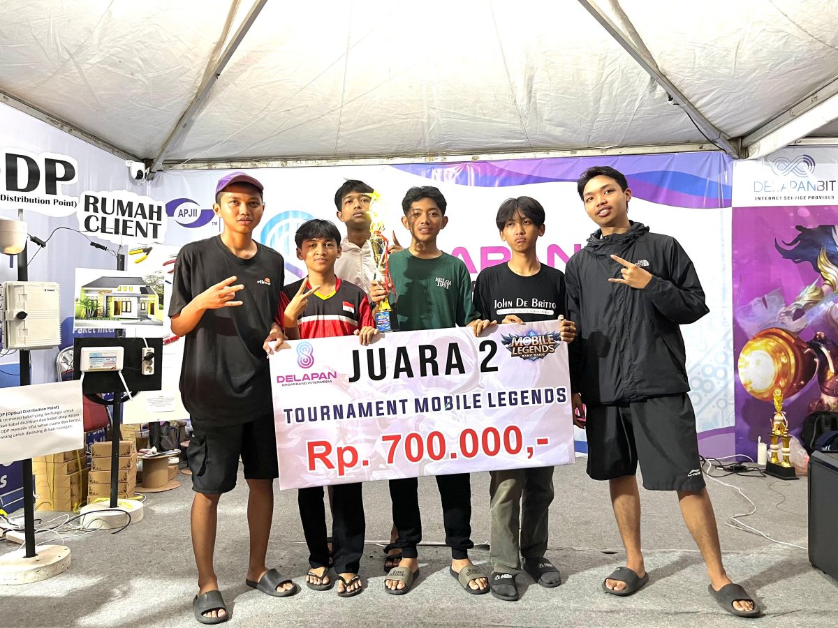 Tim pemenang Juara 2 Turnamen Mobile Legends DelapanBit berfoto bersama memegang piala dan banner hadiah