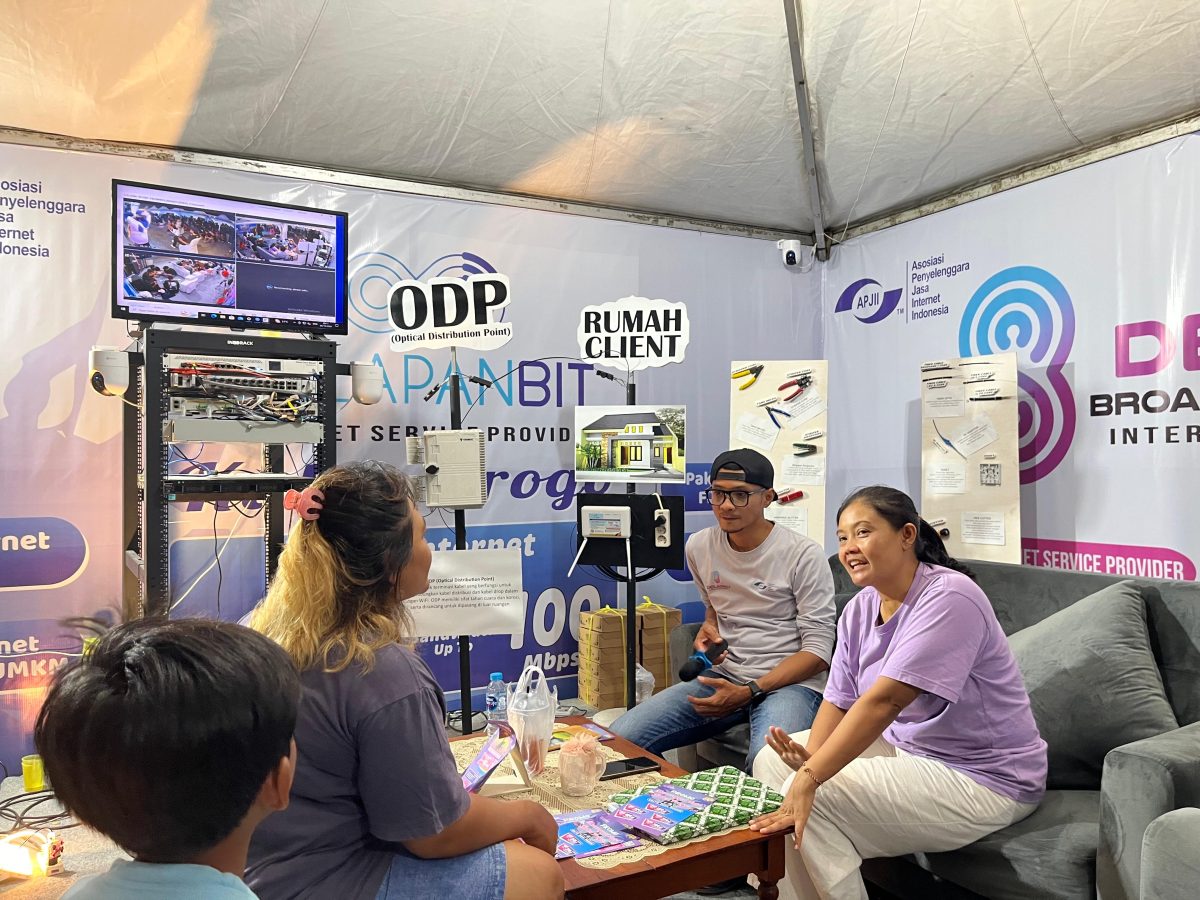 Tim marketing DelapanBit memberikan explanation layanan internet kepada calon pelanggan di booth pameran