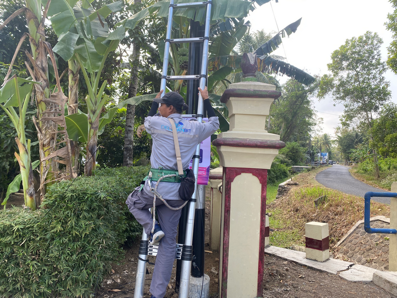 Teknisi memanjat tangga memasang ODP di tiang