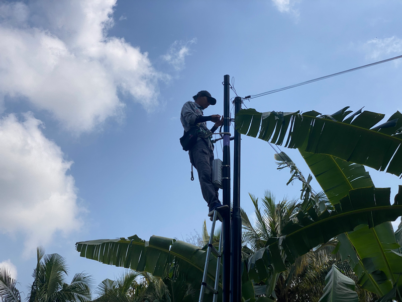 Teknisi menarik kabel drop core di tiang udara