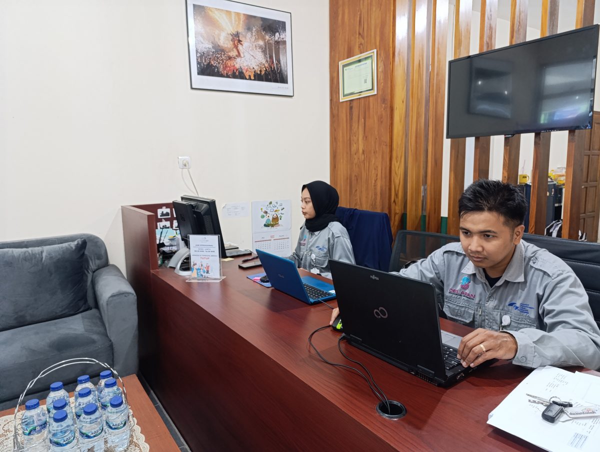Staf customer service DelapanBit melayani pelanggan di meja administrasi kantor