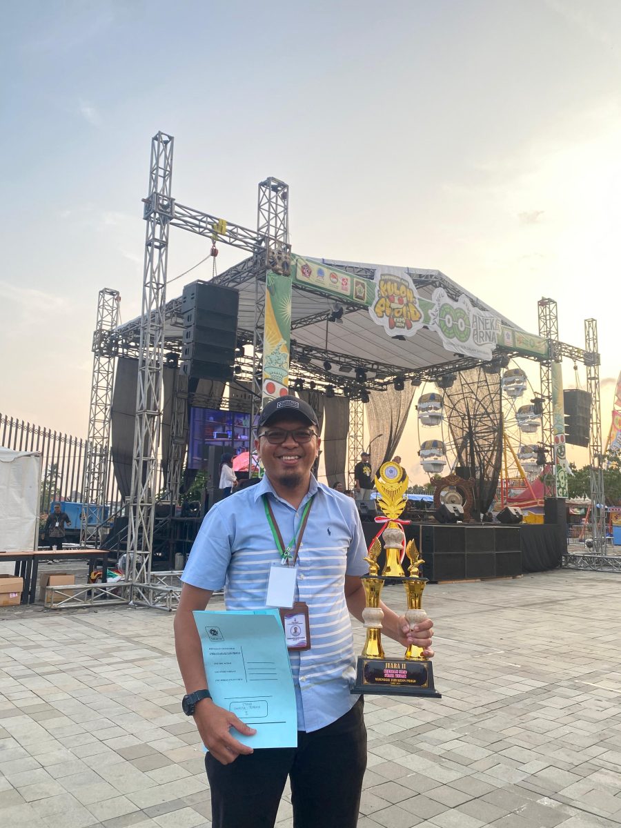 Perwakilan DelapanBit memegang piala Juara 2 Stand Terbaik di Manunggal Fair Kulon Progo