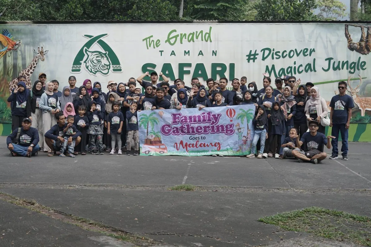 Keluarga besar DelapanBit berfoto bersama dengan banner Family Gathering Goes to Malang di Taman Safari